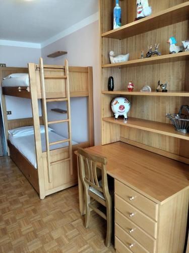 a room with a bunk bed and a desk and a desk at Casa Elvezia in Breuil-Cervinia