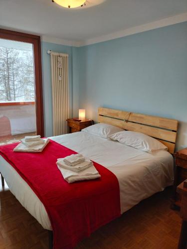 a bedroom with a large bed with towels on it at Casa Elvezia in Breuil-Cervinia