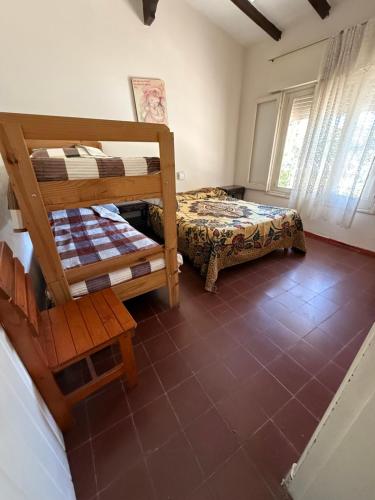 a bedroom with two bunk beds and a chair at Nuevo complejo Clarita in Villa Carlos Paz