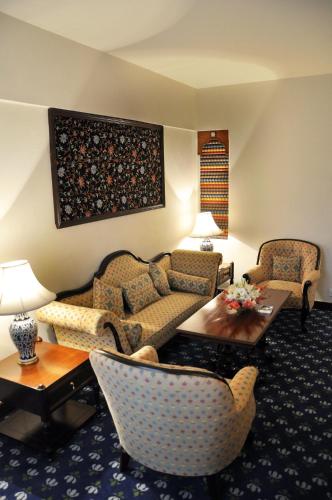 a living room with a couch and chairs and a table at Faisalabad Serena Hotel in Faisalabad