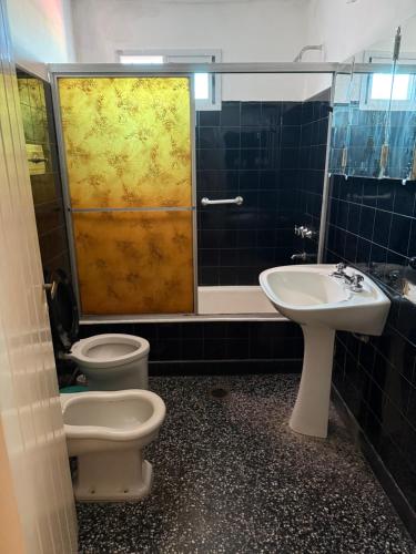 a bathroom with two toilets and a sink and a shower at Nuevo complejo Clarita in Villa Carlos Paz
