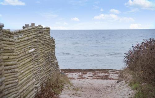 a stone wall next to the ocean on a beach at Beautiful Home In Gørlev With Wifi in Gørlev