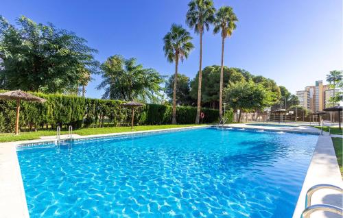 einen Pool mit blauem Wasser und Palmen in der Unterkunft Beautiful Apartment In Campello in El Campello