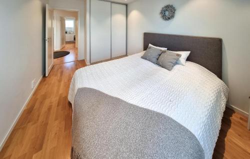 a bedroom with a bed with white sheets and blue pillows at Beach Front Home In Rönnäng With Sauna in Rönnäng
