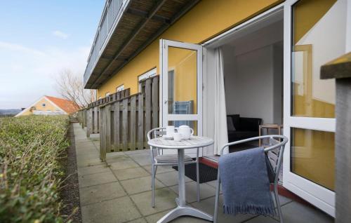 Un patio con una mesa y sillas en un balcón. en Cozy Apartment In Gudhjem, en Gudhjem