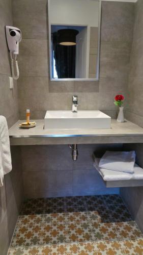 a bathroom with a sink and a mirror at Hotel Relais Du Postillon in Antibes