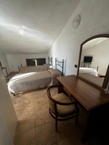 a bedroom with two beds and a mirror and a desk at Agriturismo Quota 700 in Sicignano degli Alburni