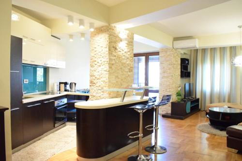 a kitchen and living room with a bar and a couch at Urban Vibe Apartments 2 in Skopje