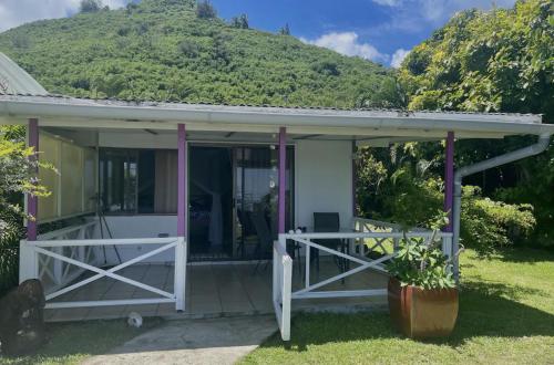 a cottage with a mountain in the background at Te fare iti - Bungalow bord de mer in Maharepa