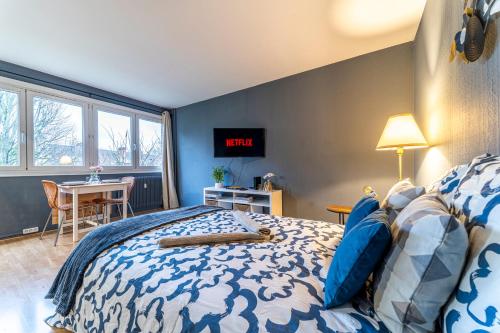 - une chambre avec un lit et une table dans l'établissement L'Azur - Parking privé - Hypercentre - Wifi, à Marcq-en-Barœul