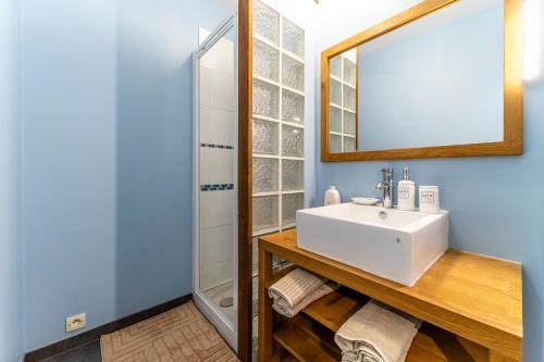 une salle de bain avec un lavabo et un miroir dans l'établissement L'Azur - Parking privé - Hypercentre - Wifi, à Marcq-en-Barœul