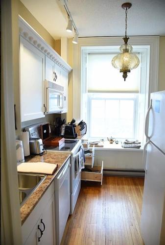 a kitchen with a window and a sink and a stove at Noble Waterfront Suites in Brockville