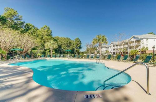 a swimming pool with chairs in a resort at Cozy 2BR at Barefoot! Perfect for 4! Unit 414 in North Myrtle Beach