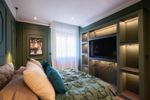 a bedroom with a bed and a flat screen tv at MENTORE MAISON PRESTiGE in Noceto