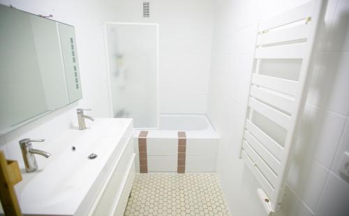 une salle de bain blanche avec un lavabo et une douche dans l'établissement Spacieux & Lumineux Proche de Paris & Versailles, à Vélizy-Villacoublay