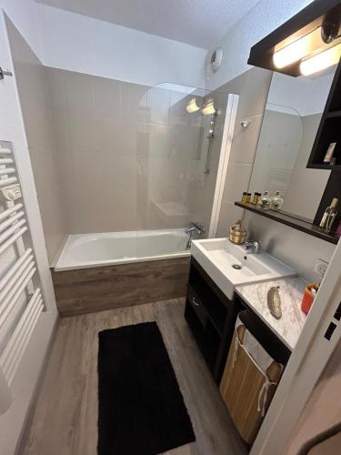 une salle de bain avec une baignoire et un lavabo dans l'établissement Superbe appartement avec piscine et garage, à Péone