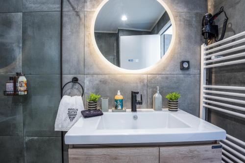 a bathroom with a white sink and a mirror at AEOLIS SUITES in Athens