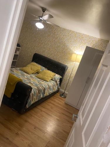 a bedroom with a bed with yellow pillows on it at LA Mansion in Wednesbury