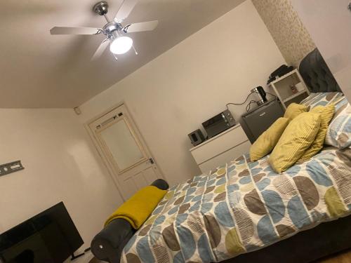 a bedroom with a bed and a ceiling fan at LA Mansion in Wednesbury
