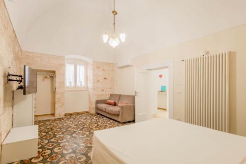a bedroom with a bed and a couch at Antiche Mura Apartments"Bianco di Puglia" cucina 1 camera da letto più divano letto in Turi