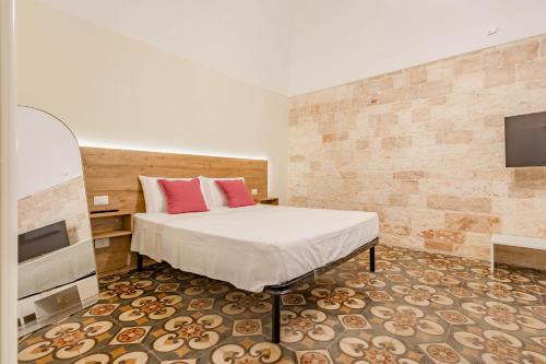 a bedroom with a bed and a flat screen tv at Antiche Mura Apartments"Bianco di Puglia" cucina 1 camera da letto più divano letto in Turi