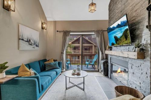 a living room with a blue couch and a fireplace at Renovated Ski In Ski Out Condo at Holiday Valley in Ellicottville