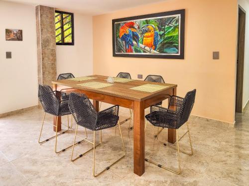 a dining room table with chairs and a painting on the wall at Finca,lago de pesca,piscina natural,moderna in Rionegro