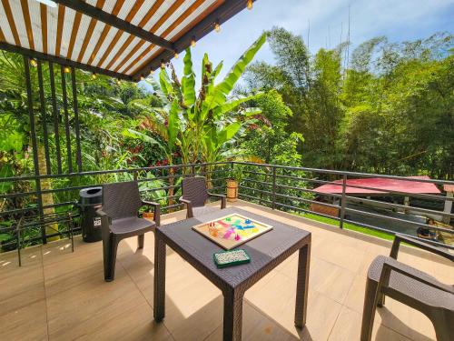 a patio with a table and chairs on a balcony at Finca,lago de pesca,piscina natural,moderna in Rionegro