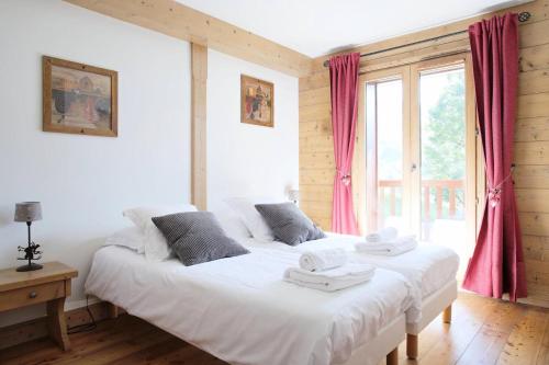 une chambre avec un grand lit blanc avec des serviettes dessus dans l'établissement Les Chalets Du Gypse - LES CHALETS DU GYPSE C05 MAE-3611, à Saint-Martin-de-Belleville