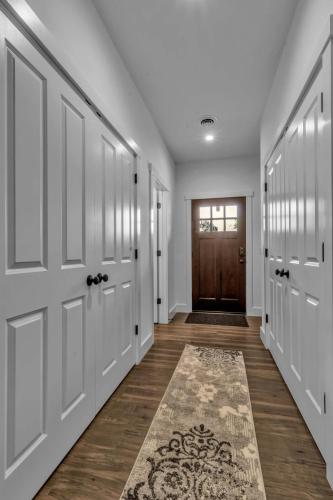 a hallway with white doors and a rug at Spacious Townhome with Fireplace in Ellicottville