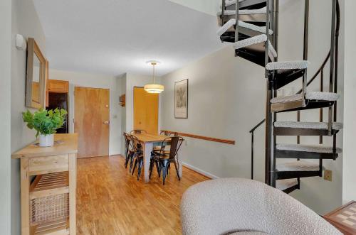 a living room with a table and a spiral staircase at Updated Ski In Ski Out Condo Holiday Valley in Ellicottville