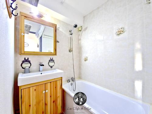 une salle de bain avec un lavabo, une baignoire et un miroir dans l'établissement Idéal vacances Studio 4 personnes Jolie vue sud !, à Huez