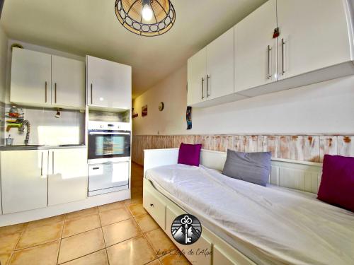 - une chambre avec un grand lit et des oreillers violets dans l'établissement Idéal vacances Studio 4 personnes Jolie vue sud !, à Huez