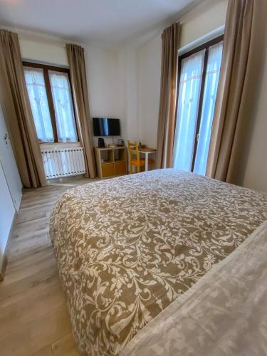 a bedroom with a bed and two windows at Il Giardino Segreto in Assisi
