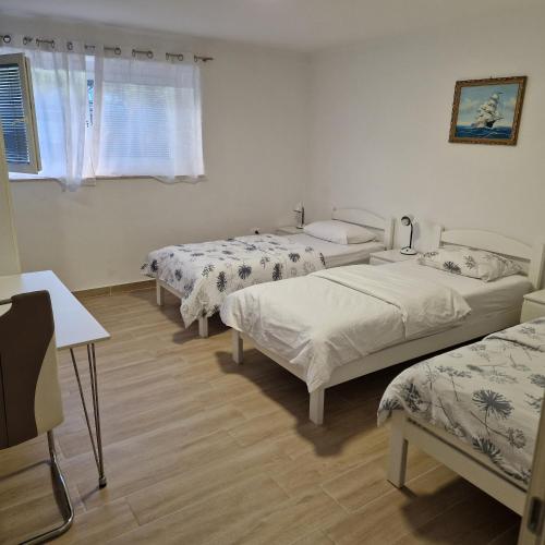 a room with three beds and a window at Apartman Maksimirska 89 Zagreb in Zagreb