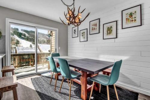 a dining room with a wooden table and green chairs at Modern Townhome with Decks Fireplace & Mountain Views in Ellicottville