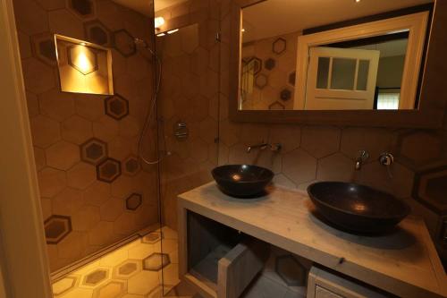 a bathroom with two sinks and a mirror at B&B Eemswolde in Delft