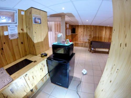 - une cuisine avec des murs en bois et une cuisinière dans l'établissement Studio le chalet Paris, à Villeneuve-le-Roi