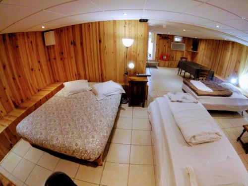 - une chambre avec 2 lits dans une pièce dotée de murs en bois dans l'établissement Studio le chalet Paris, à Villeneuve-le-Roi