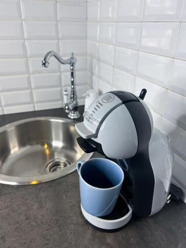 une cafetière posée sur un comptoir à côté d'un évier dans l'établissement blue sun, à Nice