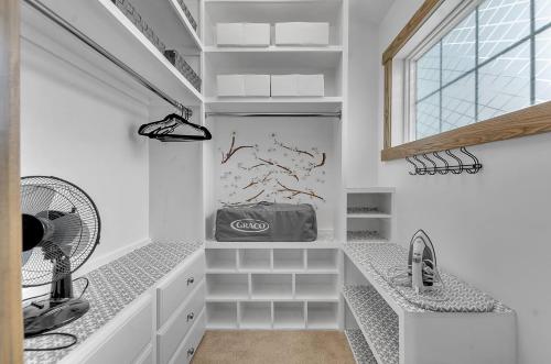 a bathroom with white counters and a sink and a window at Luxurious 3-Bedroom Townhouse Walk to Village in Ellicottville