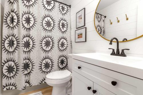 a bathroom with a sink and a toilet and a mirror at Ski In Ski Out 3-bed 2-bath Condo King Bed in Ellicottville
