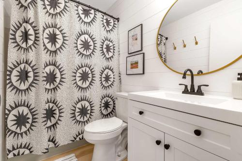 a bathroom with a sink and a toilet and a mirror at Ski In Ski Out 3-bed 2-bath Condo King Bed in Ellicottville