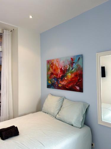 une chambre avec un lit avec un tableau sur le mur dans l'établissement blue sun, à Nice