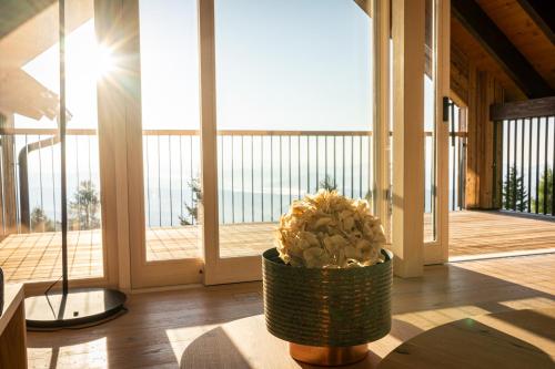 a vase with flowers in a room with a balcony at dasHuber-Hochrindl in Hochrindl