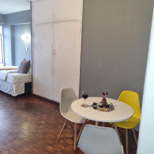 una habitación con una mesa y sillas y una cama en Colchester flat, en Durban