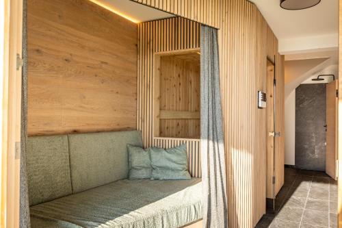 a bed in a room with a wooden wall at dasHuber-Hochrindl in Hochrindl