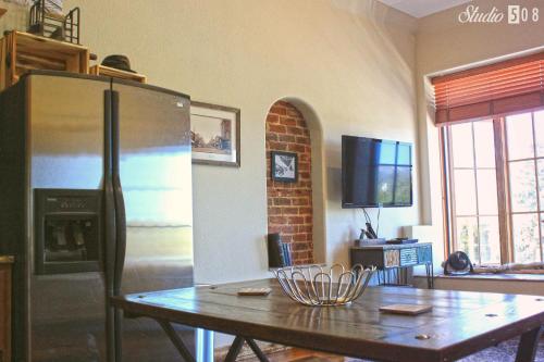 a kitchen with a wooden table and a refrigerator at Studio 508 in Leadville