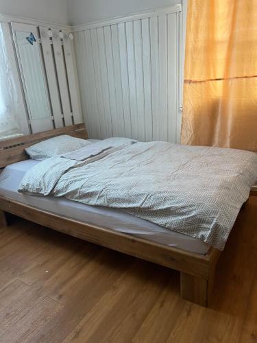 an unmade bed in a bedroom with a wooden floor at Motel Schwanen in Schlattingen