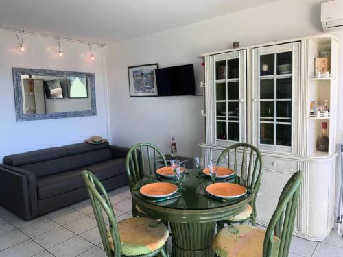 un salon avec une table, des chaises et un canapé dans l'établissement Résidence Héliopolis Bâtiment Ab - Studio 4 pers - Héliopolis Bât. AB MAE-3044, au Cap d'Agde